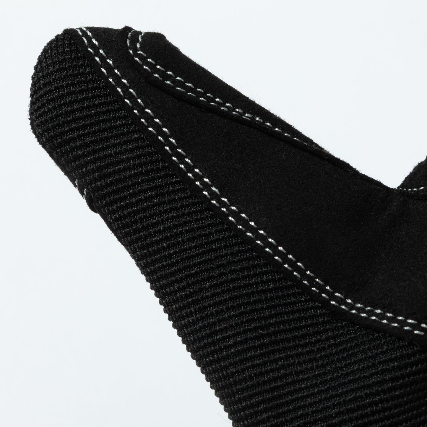 Close-up of a black bite guard gloves with white stitching on a light gray background