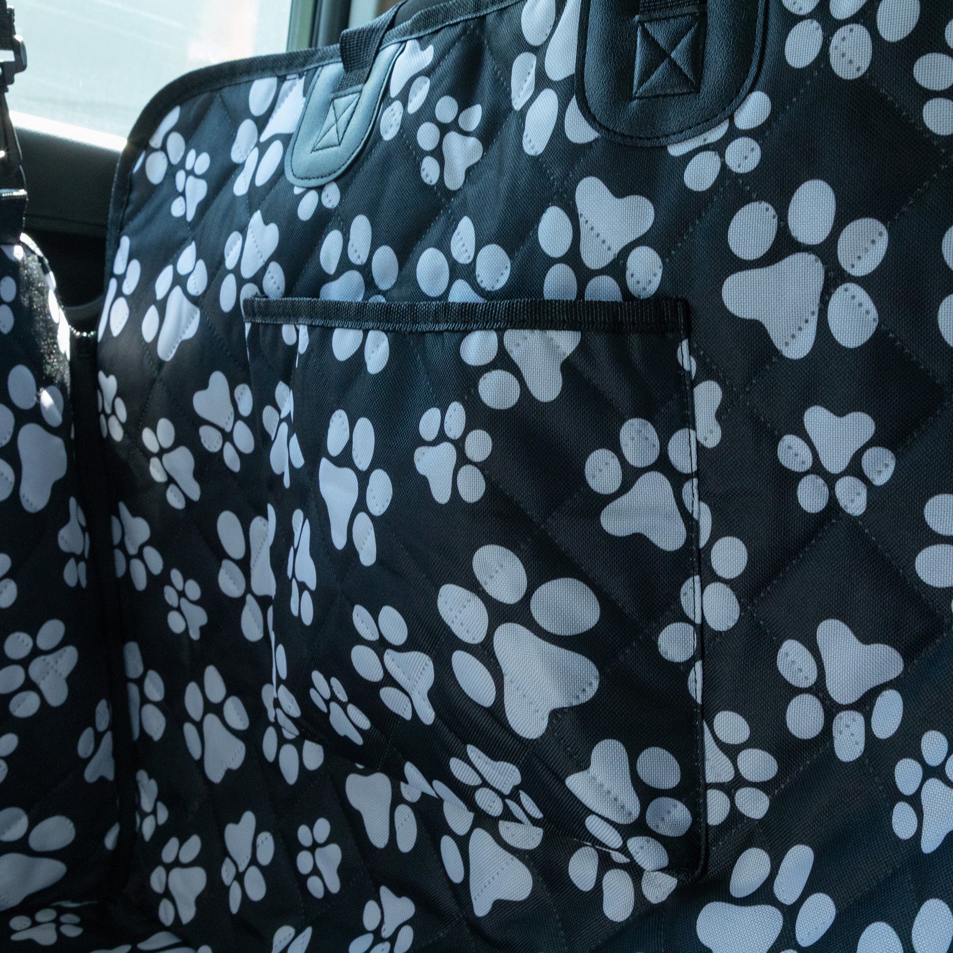Car seat cover with paw print pattern in a vehicle