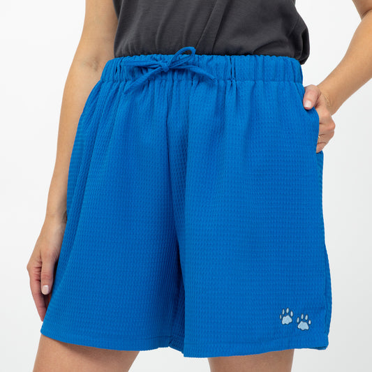 Blue shorts with paw prints on a white background