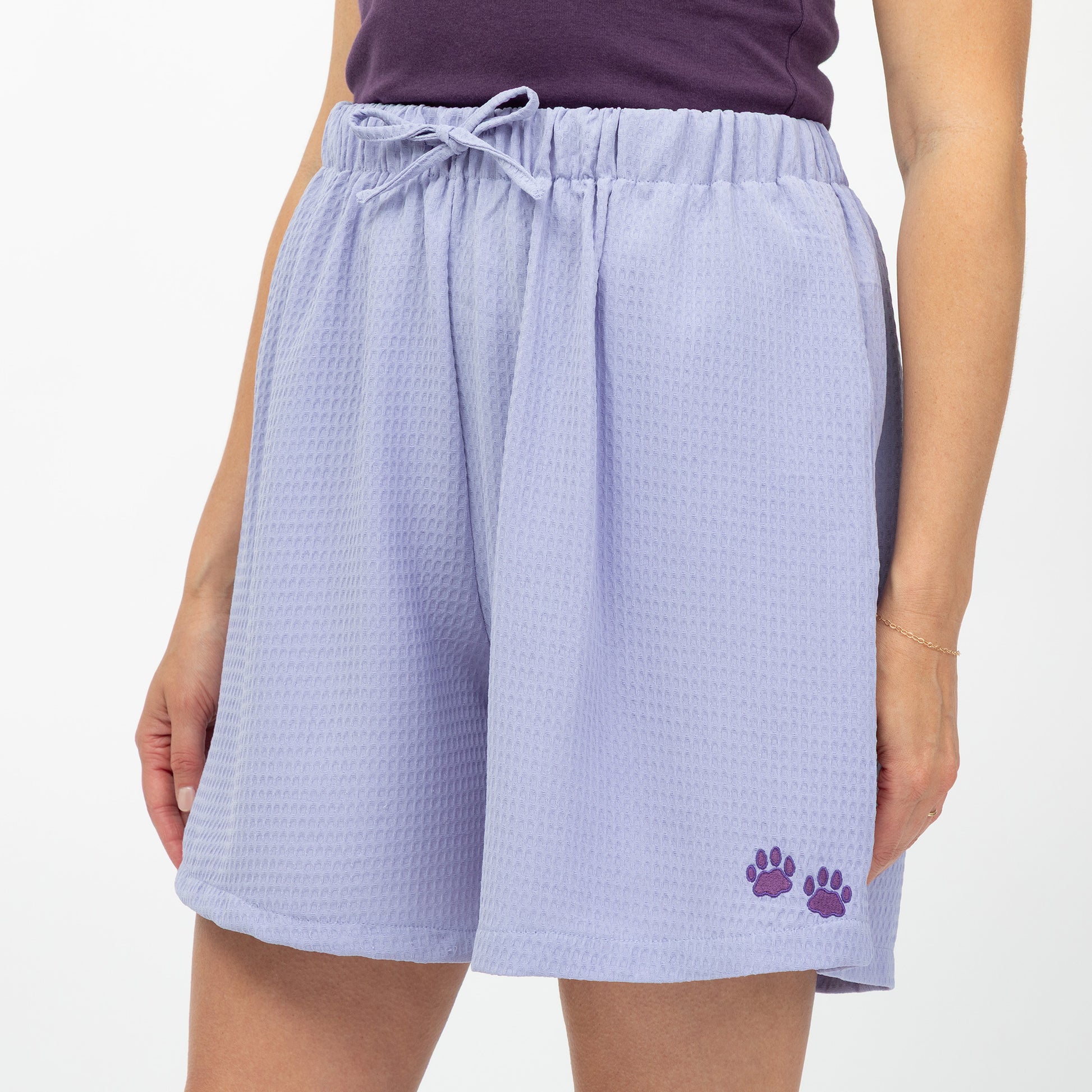 Lavender shorts with a paw print on a white background