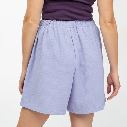 Light purple shorts worn by a person on a white background