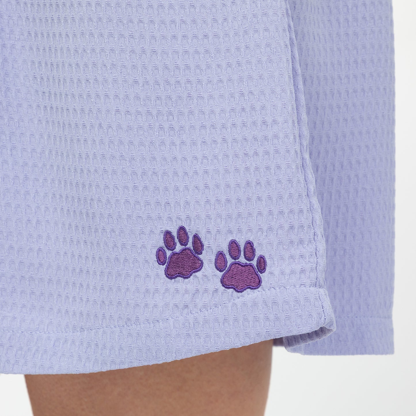 Light purple waffle weave shorts with embroidered paw prints on a white background