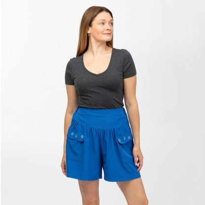 Woman wearing a gray shirt and blue shorts on a white background