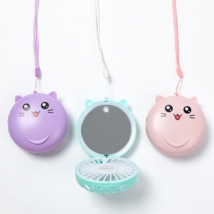 Three cute cat-face compact fans hanging on white strings against a white background. The left fan is purple and closed, the center fan is mint green and open showing a mirror and fan blades, and the right fan is pink and closed.