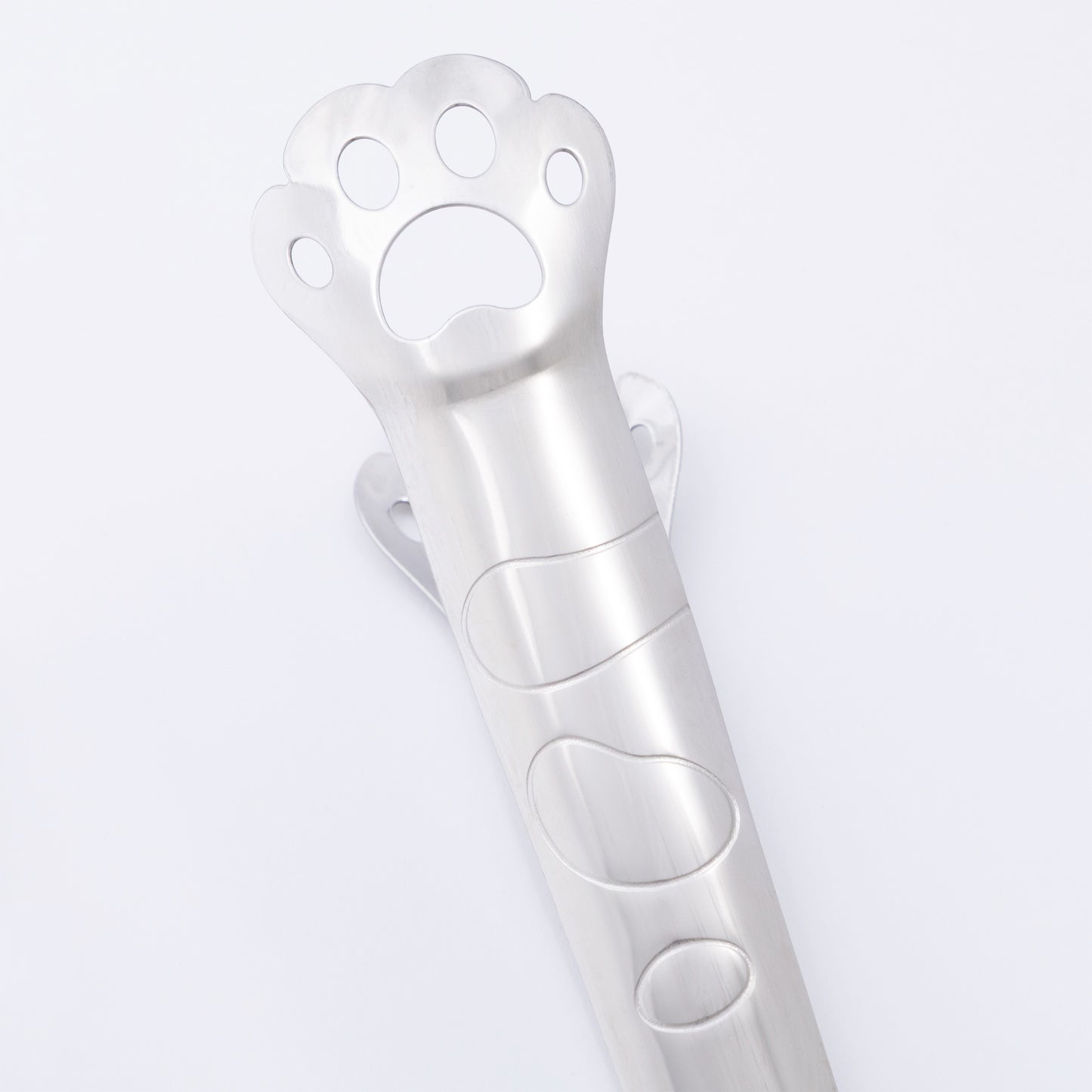 Metallic paw-shaped tongs on a light gray background