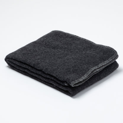 A folded dark charcoal gray wool blanket with a textured surface and a visible stitched border, photographed on a clean white background.