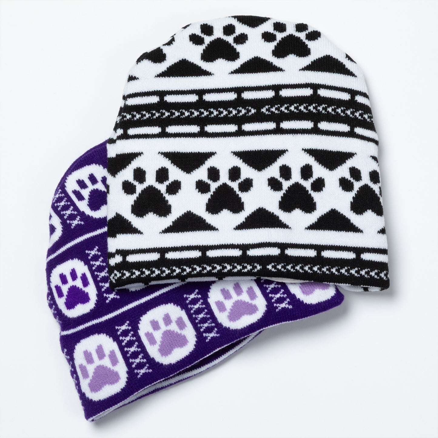 Two knit hats with paw print pattern on a white background