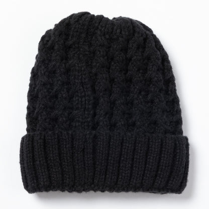Black cable knit beanie on a white background.