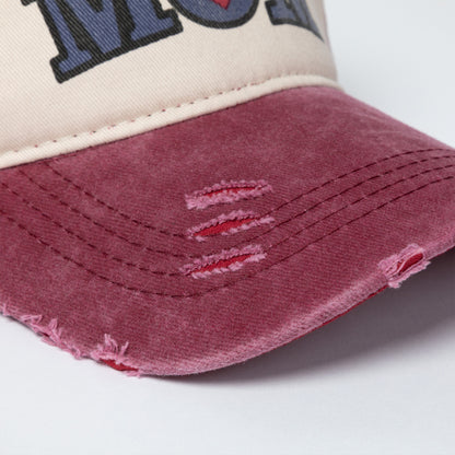 Close-up of a distressed baseball cap with a white and red design on a light gray background