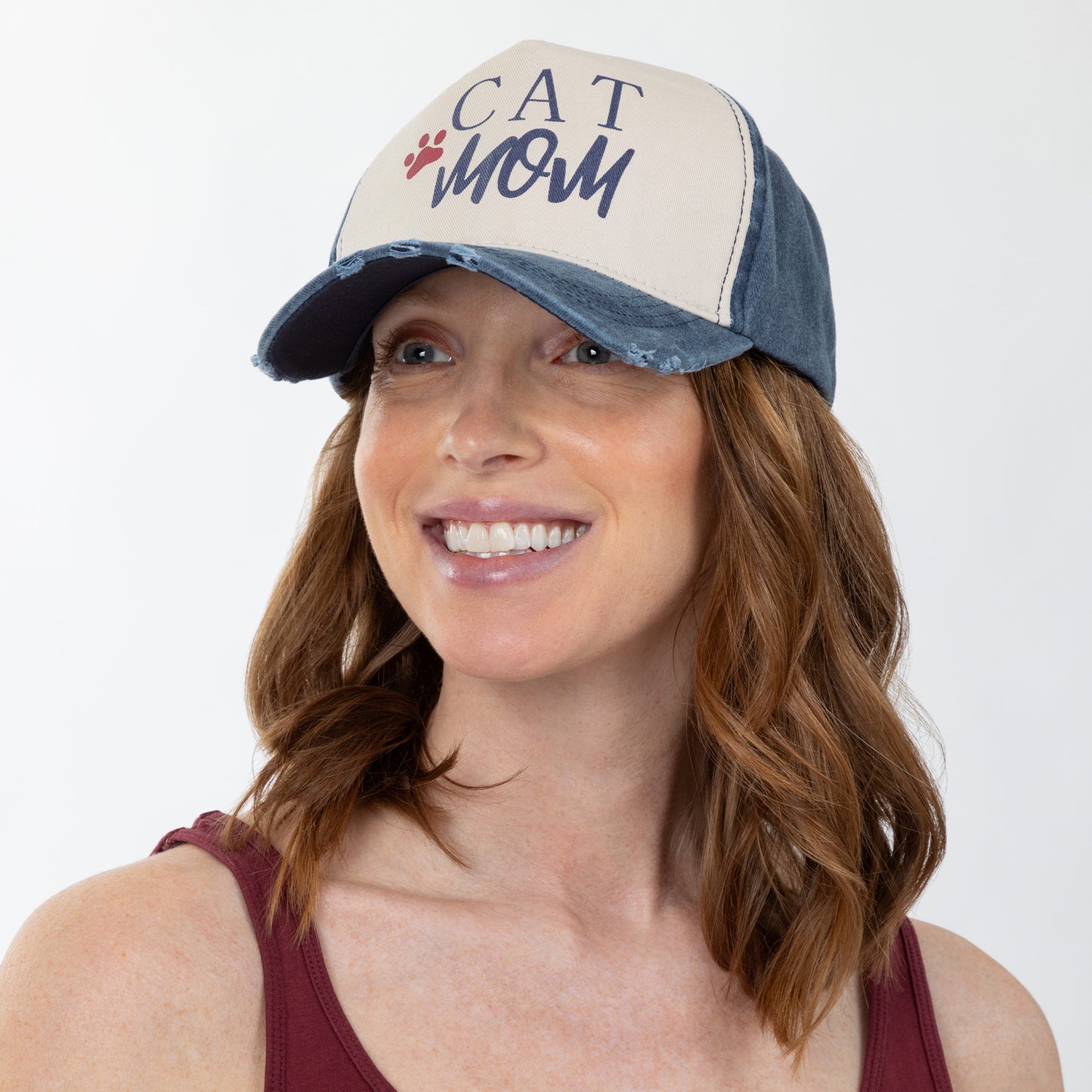 Woman wearing a cap with 'CAT MOM' text on a white background