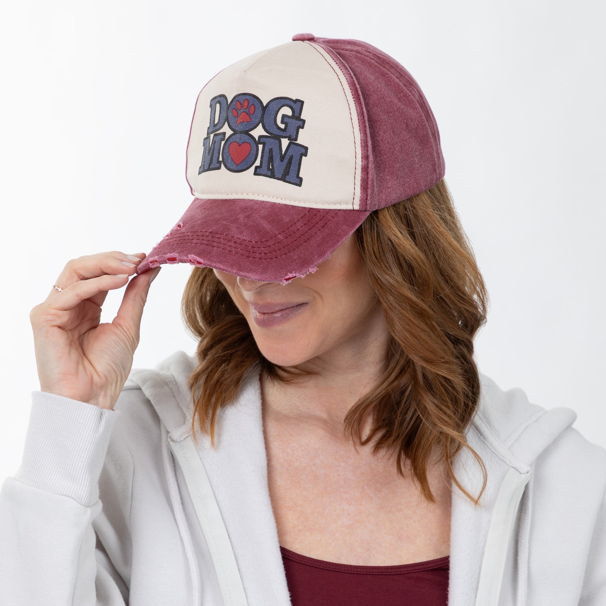 Woman wearing a 'Dog Mom' cap with a white background