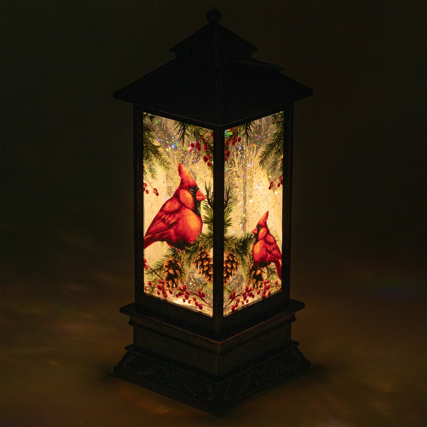 Decorative lantern with red cardinals and Christmas elements on a dark background
