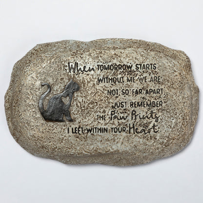 Decorative stone with a cat silhouette and engraved text on a white background