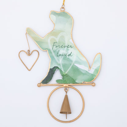 Decorative chime hanging with a green dog silhouette, heart, and bell on a white background