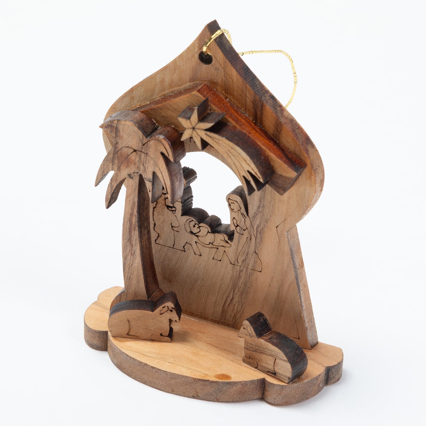 Handcrafted wooden nativity scene ornament featuring carved figures of Mary, Joseph, baby Jesus, a palm tree, and animals on a round base, with a gold hanging string at the top, shown against a plain white background.