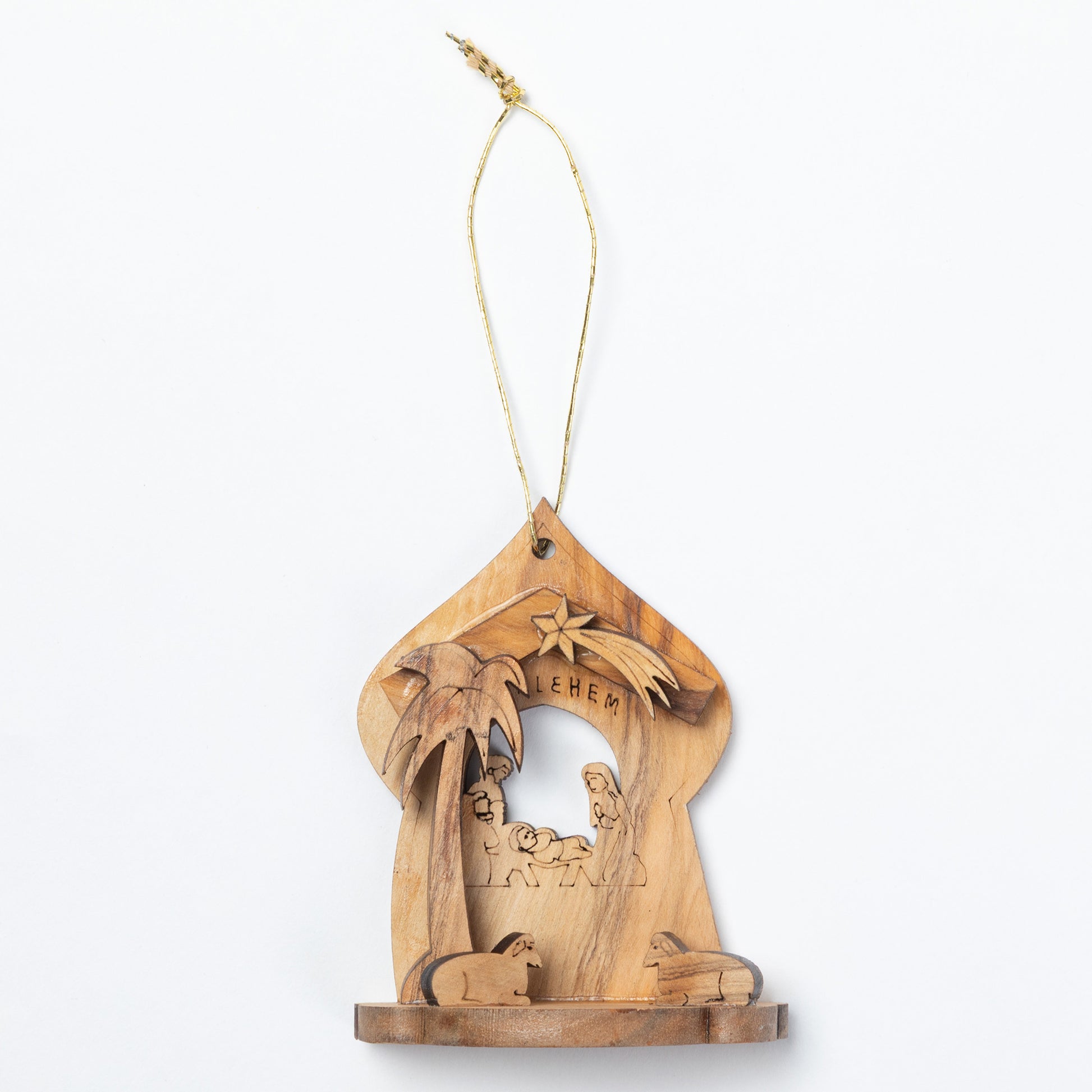 A handcrafted olive wood nativity ornament featuring a carved stable with a palm tree, star, baby Jesus, and animals, suspended by a natural jute string on a white background.