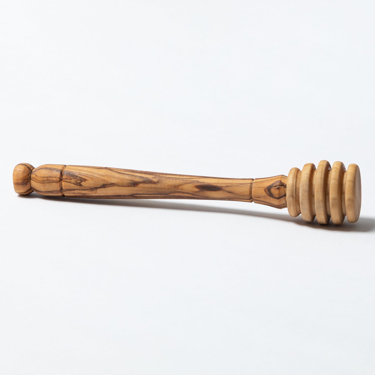 A handmade olive wood honey dipper shown against a plain white background.