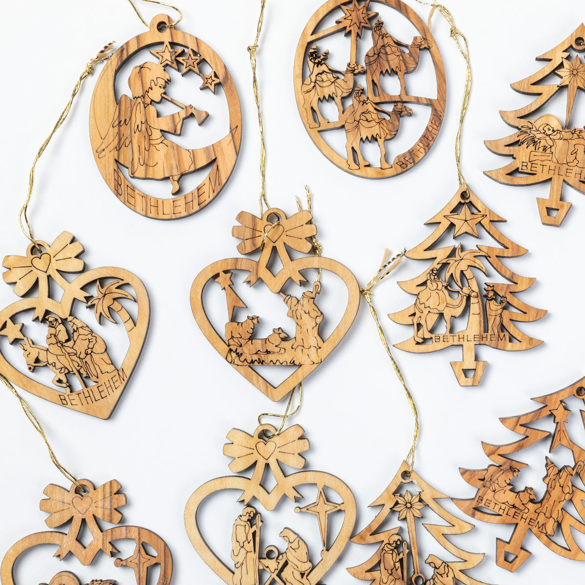 A collection of laser-cut wooden Christmas ornaments in various shapes including hearts, trees, and circles, each featuring engraved nativity scenes and the word 'BETHLEHEM' on a white background.