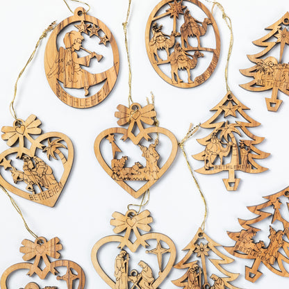 A collection of laser-cut wooden Christmas ornaments in various shapes including hearts, trees, and circles, each featuring engraved nativity scenes and the word 'BETHLEHEM' on a white background.