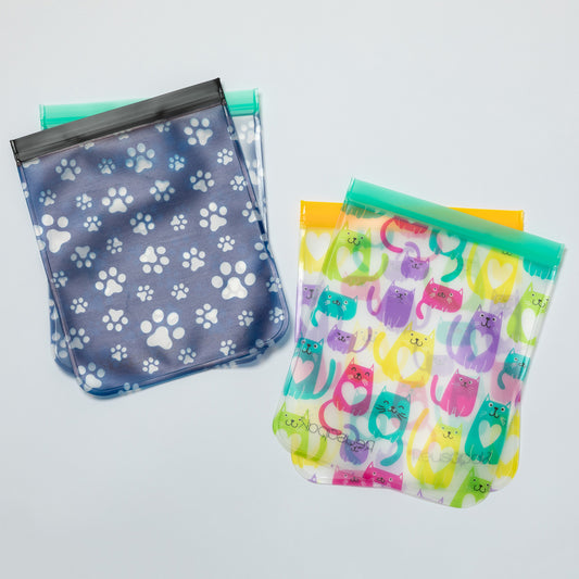 Two reusable bags with paw print and cat pattern on a light gray background
