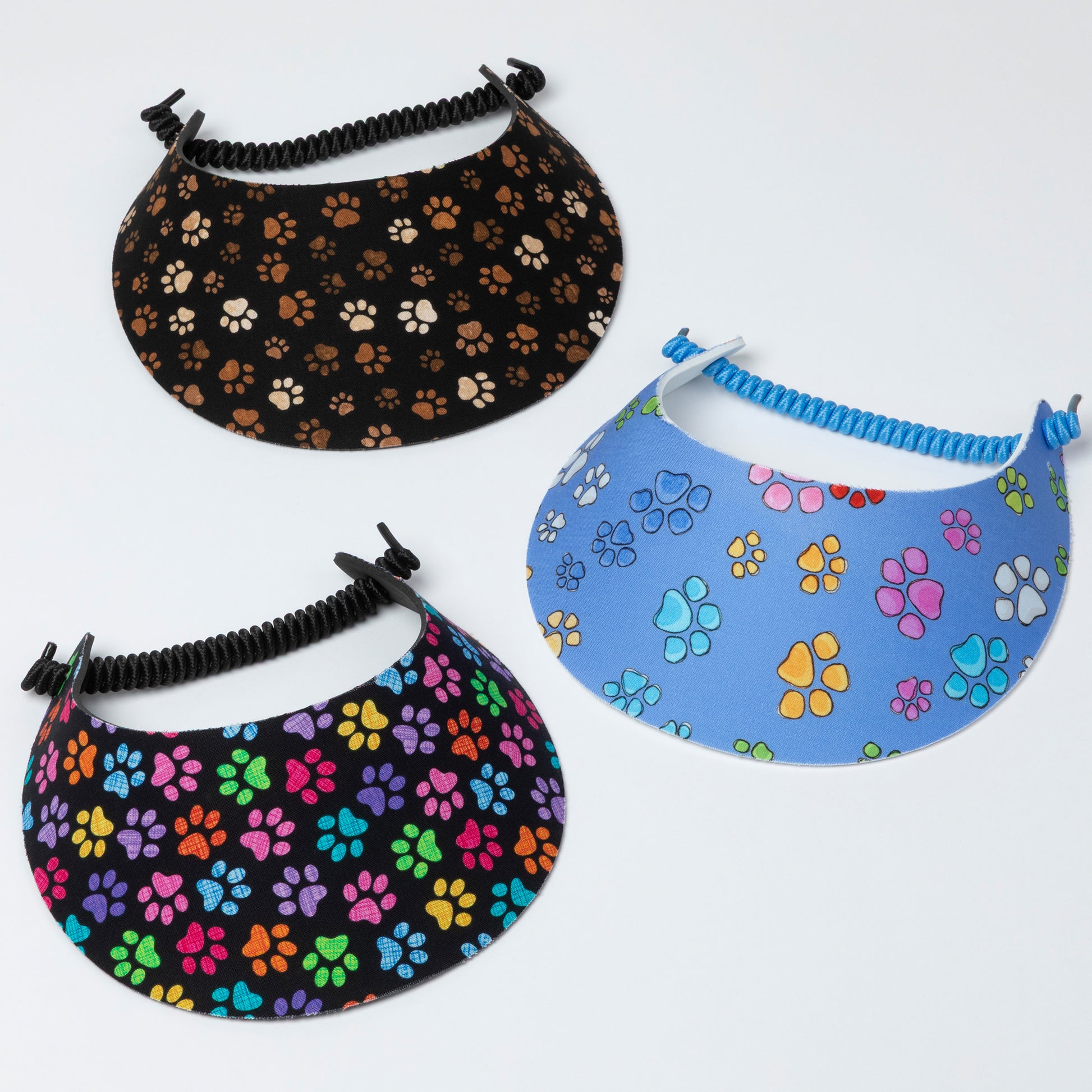Three visors with paw print patterns on a white background
