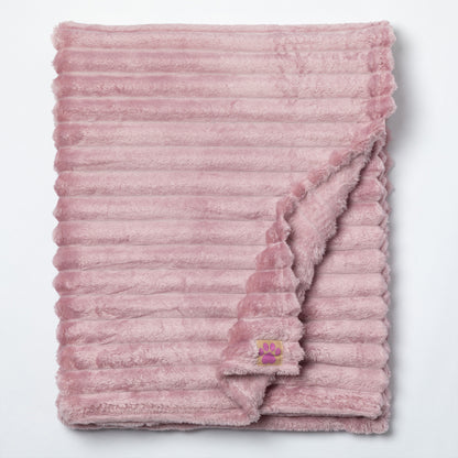 A dusty pink plush throw blanket with a ribbed corduroy-like texture, folded neatly on a white background with one corner folded over to show the soft reverse side.