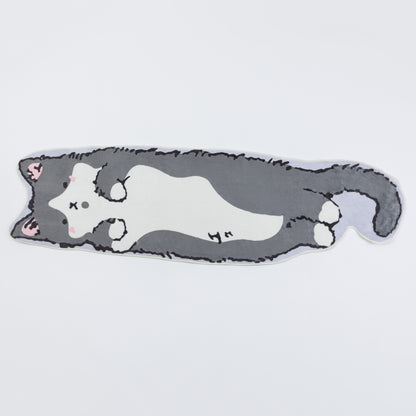 A die-cut plush cushion shaped like a sleeping gray and white cat, featuring pink inner ears and small black stitched facial details, shown on a plain light gray background.