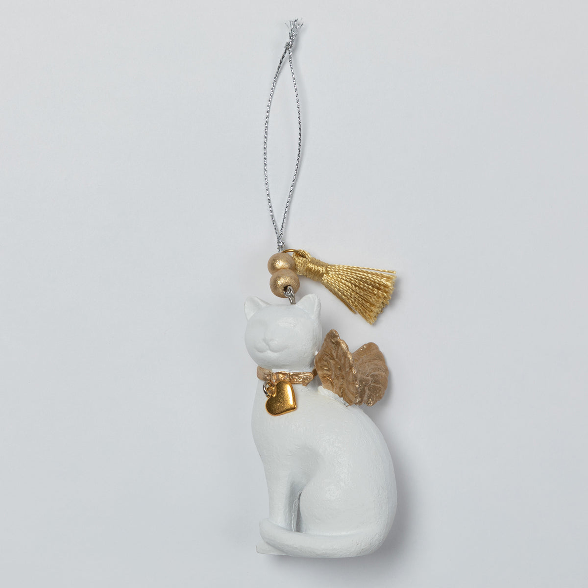 A white angel cat Christmas ornament with gold wings, a gold collar, and a gold tassel on a silver hanging string, shown against a light gray background.