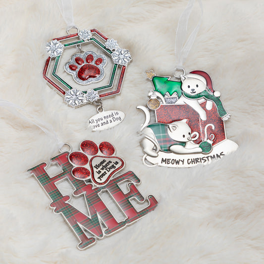 Three Christmas pet ornaments arranged on a white faux fur background. One hexagonal ornament has a red paw print and silver rhinestone border with the text 'All you need is love and a Dog.