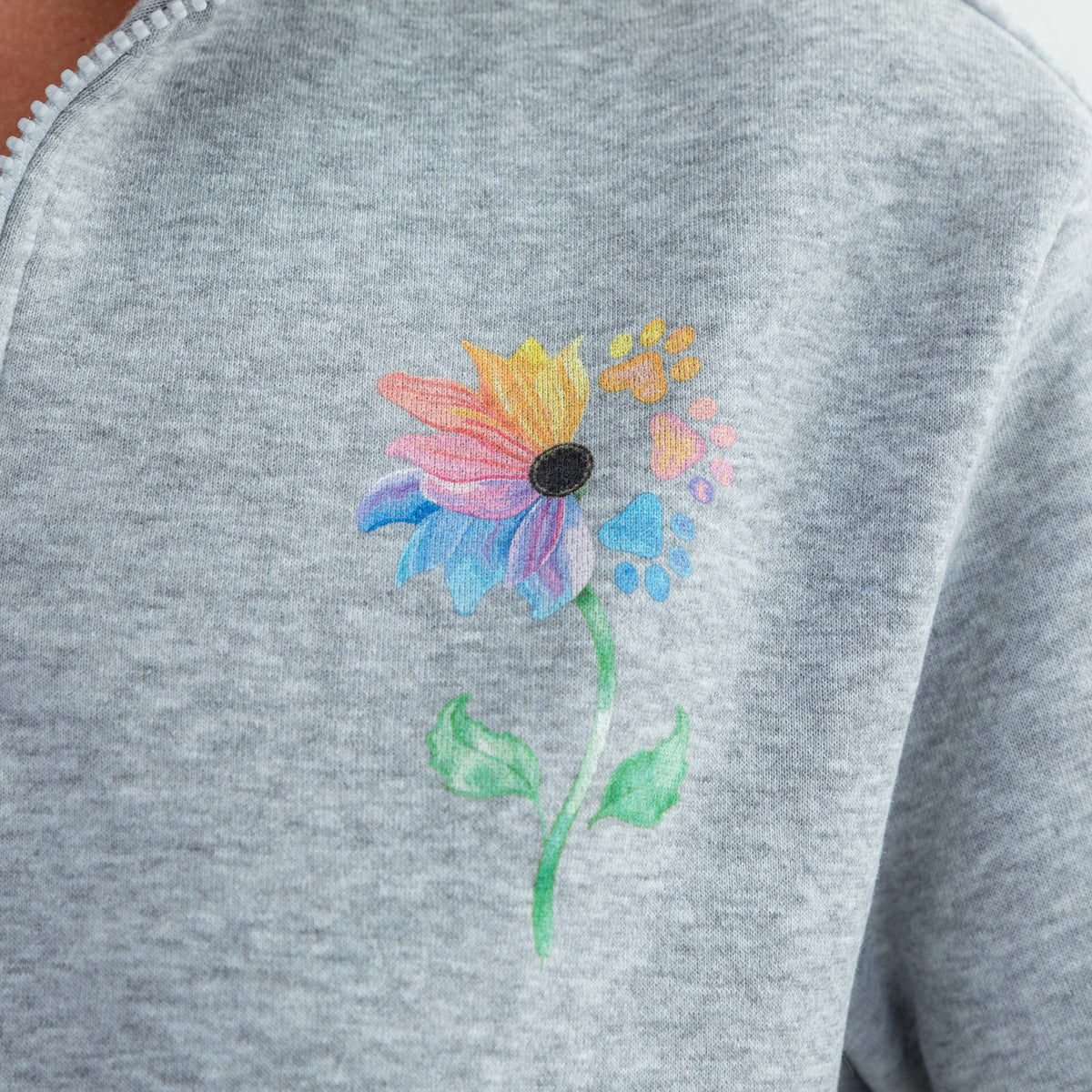 Close-up of a heather gray sweatshirt featuring a colorful flower design on the chest.