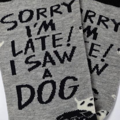 Gray socks with black text 'Sorry I'm late! I saw a dog' on a white background