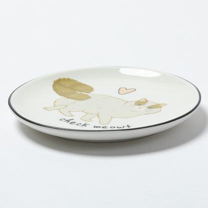 A white ceramic plate with a black rim, featuring a cute illustration of a white cat with a gold tail, a small pink heart, and the text 'check me out' in black script.