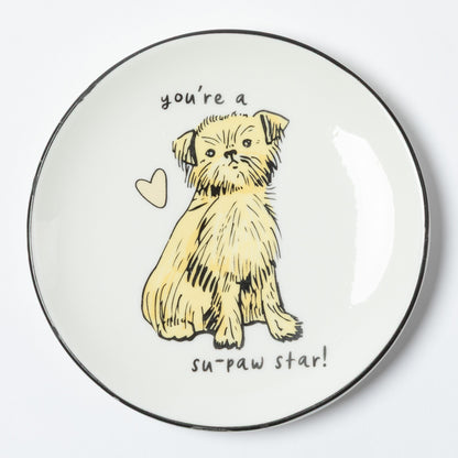 A round white ceramic plate with a black rim, featuring a hand-drawn illustration of a small yellow dog with the text 'you're a su-paw star!' and a small heart on a white background.