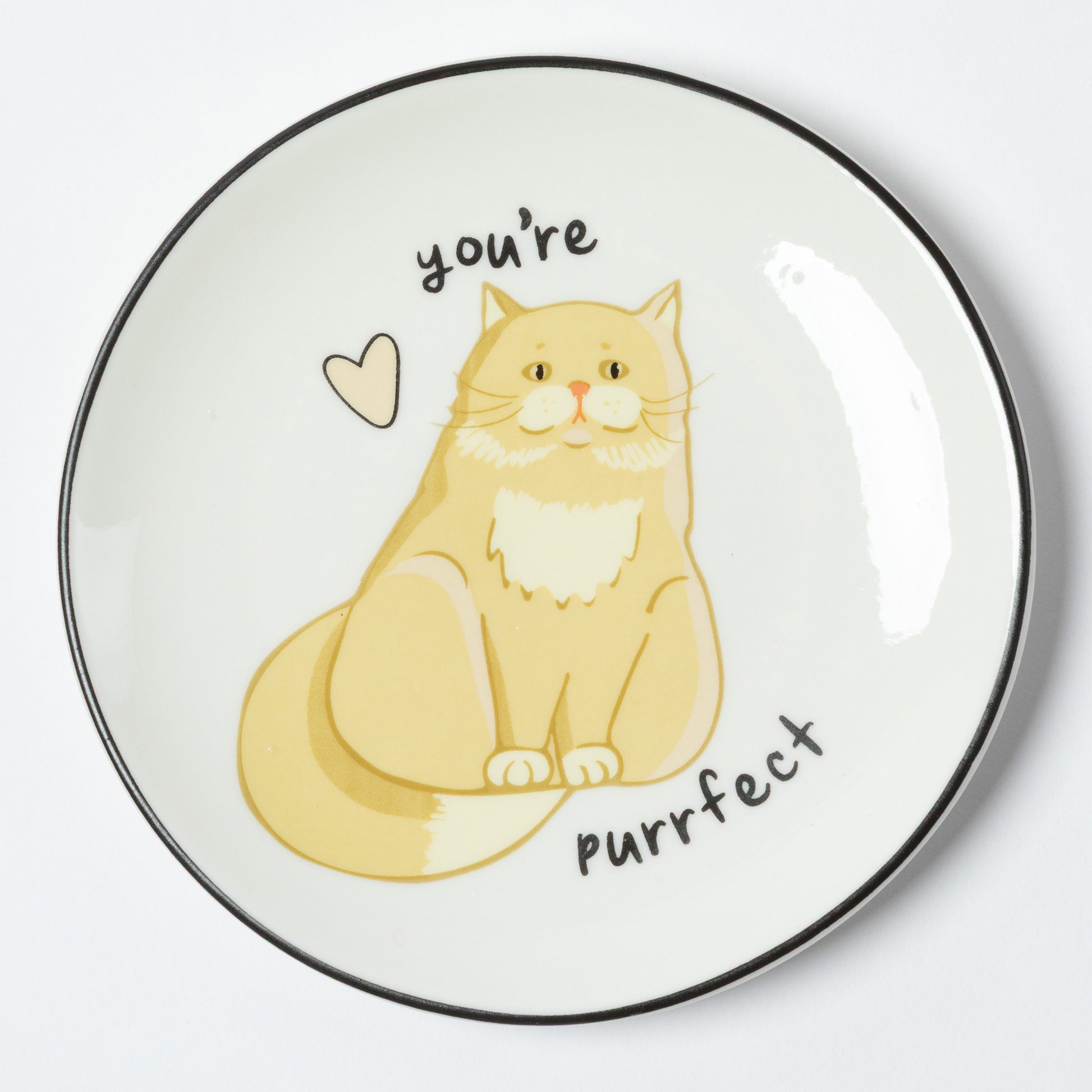 A round white ceramic plate with a black rim, featuring a cute illustration of a yellow-orange cat with the text 'you're purrfect' and a small heart.