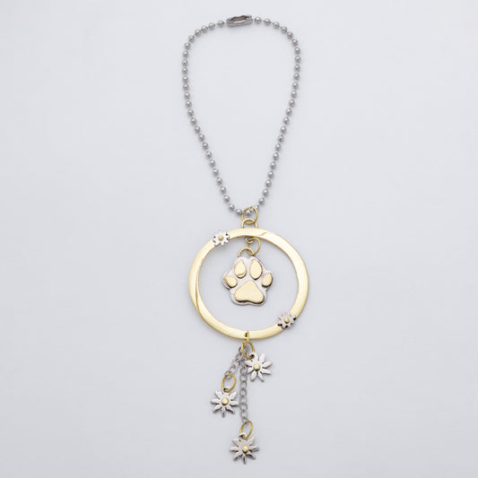 A gold and silver pet memorial necklace featuring a circular pendant with a paw print charm and dangling flower charms, shown on a light gray background.