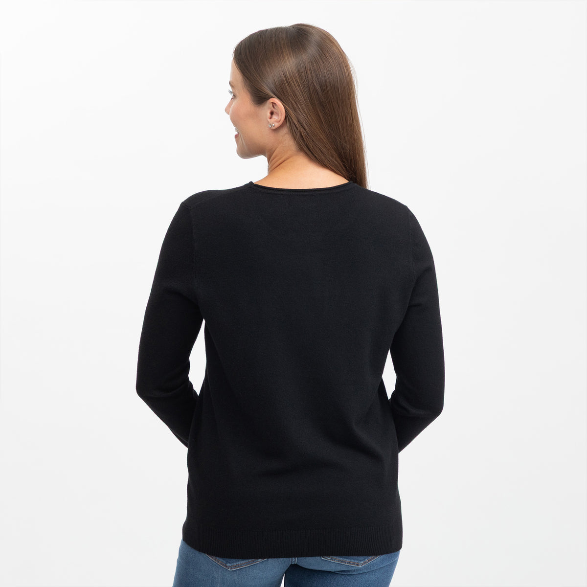 A woman viewed from the back wearing a black long-sleeve crewneck sweater and blue jeans against a plain white background.