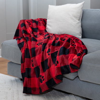 Red and black checkered blanket draped over a gray couch with a white pillow.