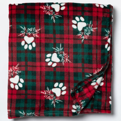 Red and green plaid blanket with white paw prints and snowflakes on a white background