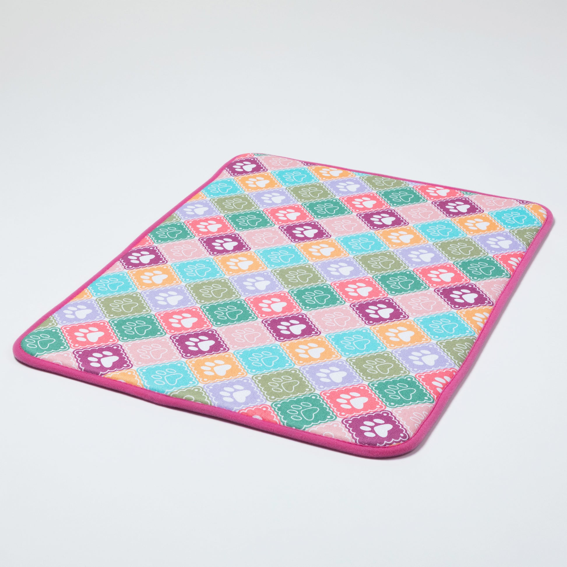 Colorful checkered mat with paw prints on a light gray background