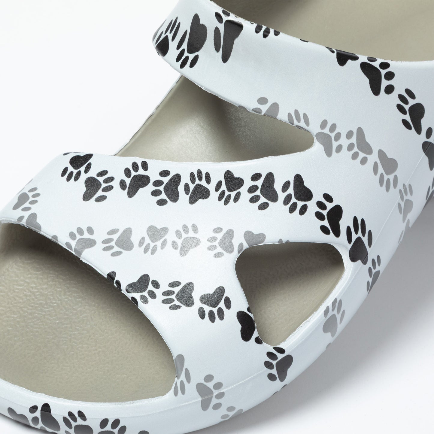 White sandal with black and gray paw print pattern on a light background