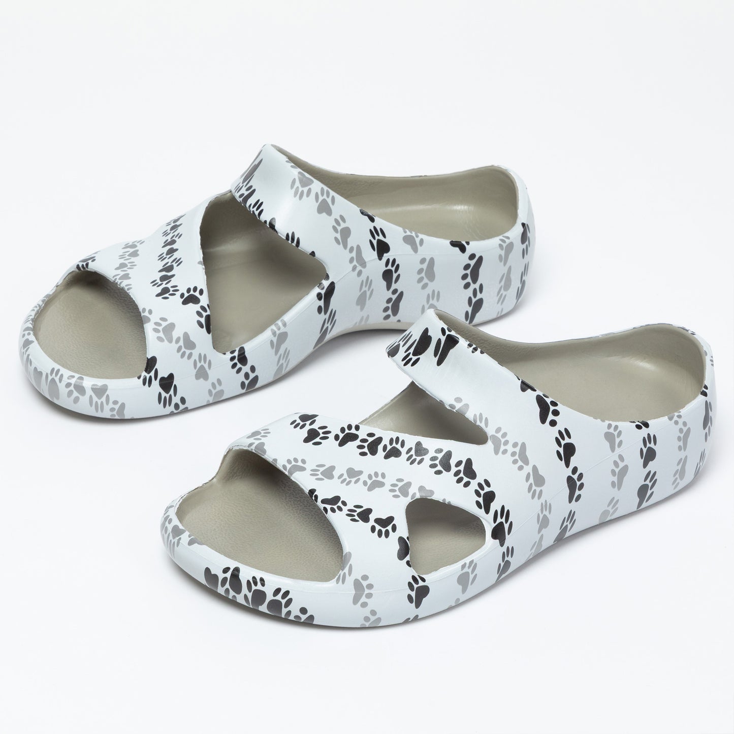 White sandals with black paw print pattern on a white background