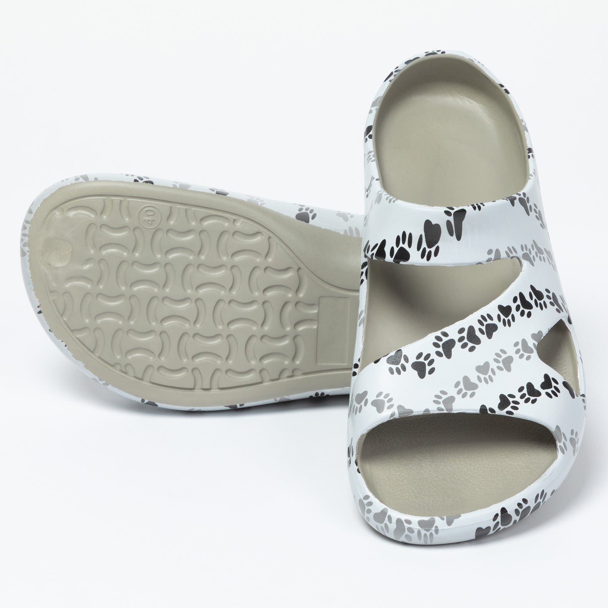 White sandal with black paw prints on a white background