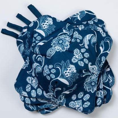 A set of four bowl cozies with various patterns, including a paw print design, blue paisley paws