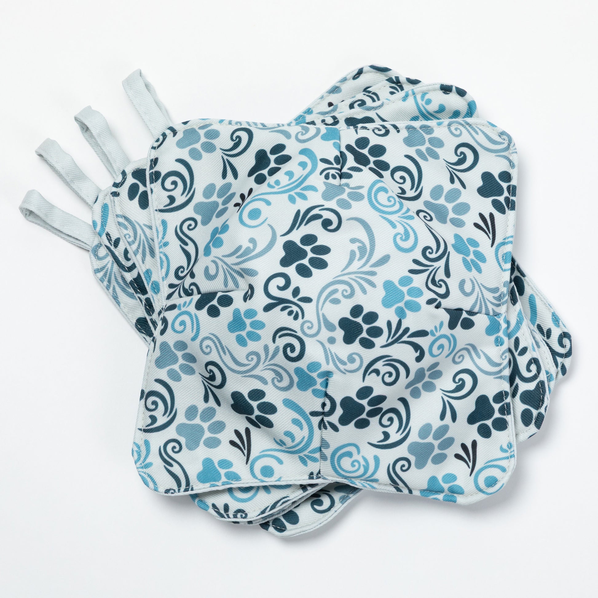 A set of four bowl cozies with various patterns, including a paw print and floral design, paw serenade