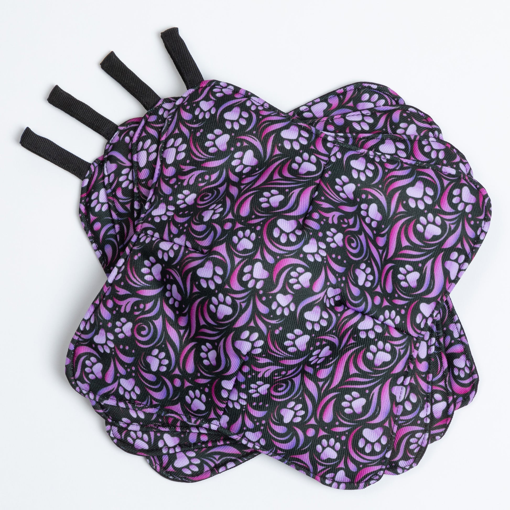 A set of four bowl cozies with various patterns, including a paw print design, paw symphony