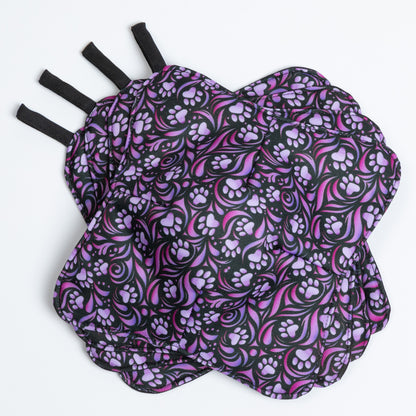 A set of four bowl cozies with various patterns, including a paw print design, paw symphony