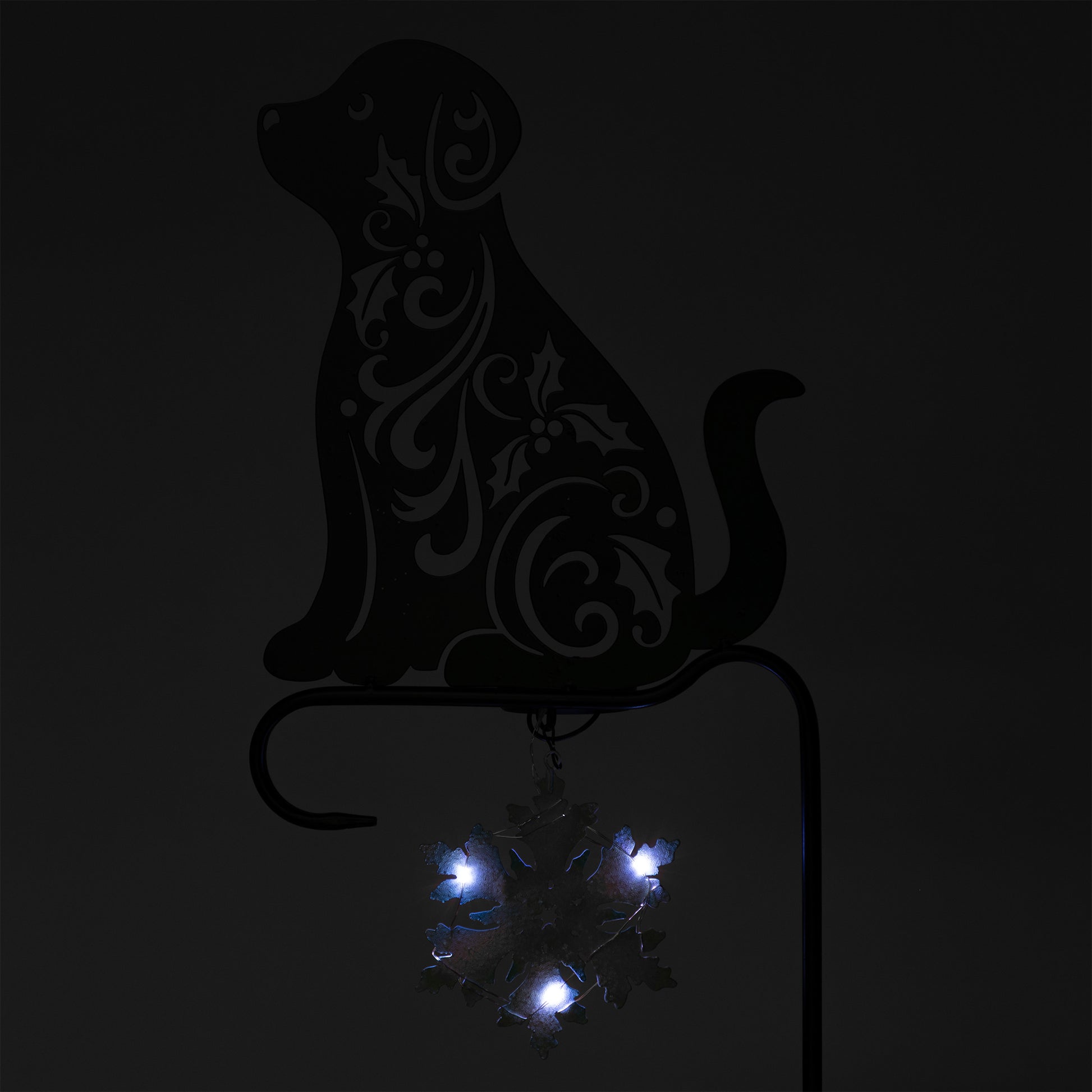 Decorative metal dog silhouette with embedded lights on a black background