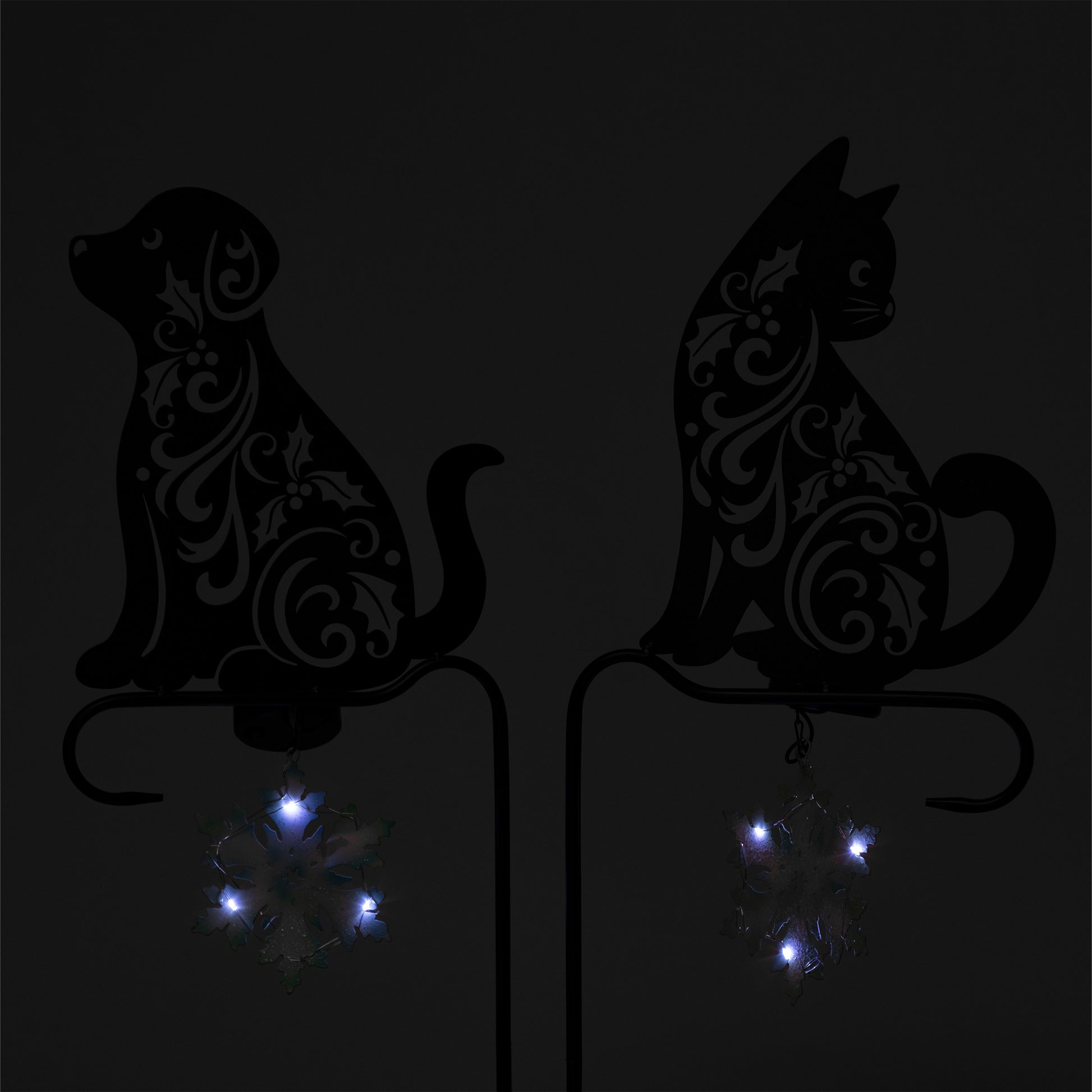Decorative silhouettes of a dog and a cat with LED lights on a dark background