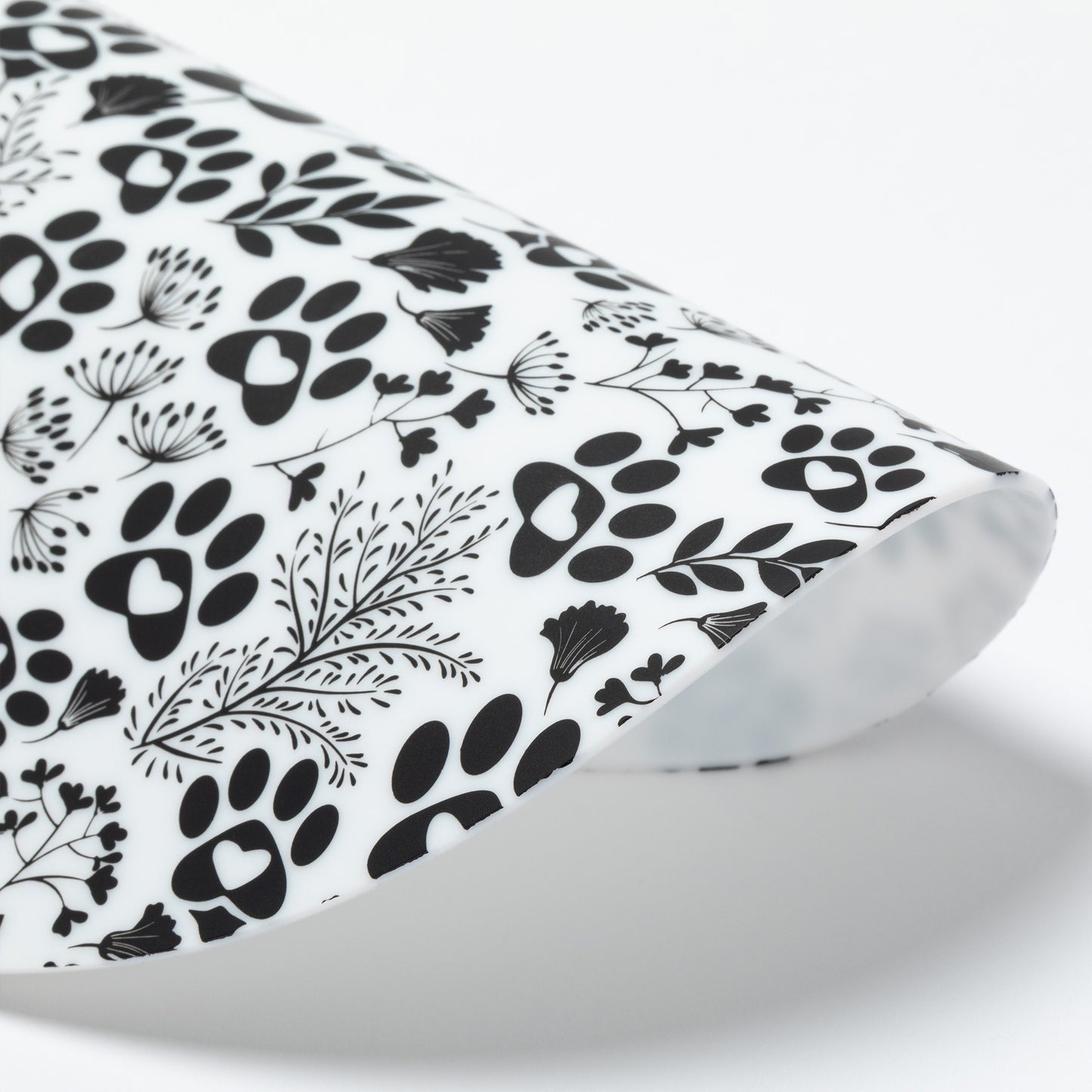 Silicone non-slip jar opener with black paw prints and leaf patterns on a white background