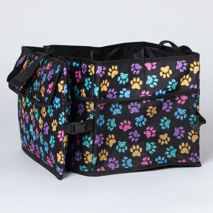 Side view of a colorful paw print patterned  car trunk organizer, with a collapsible side with a buckle, and a side mesh pocket.